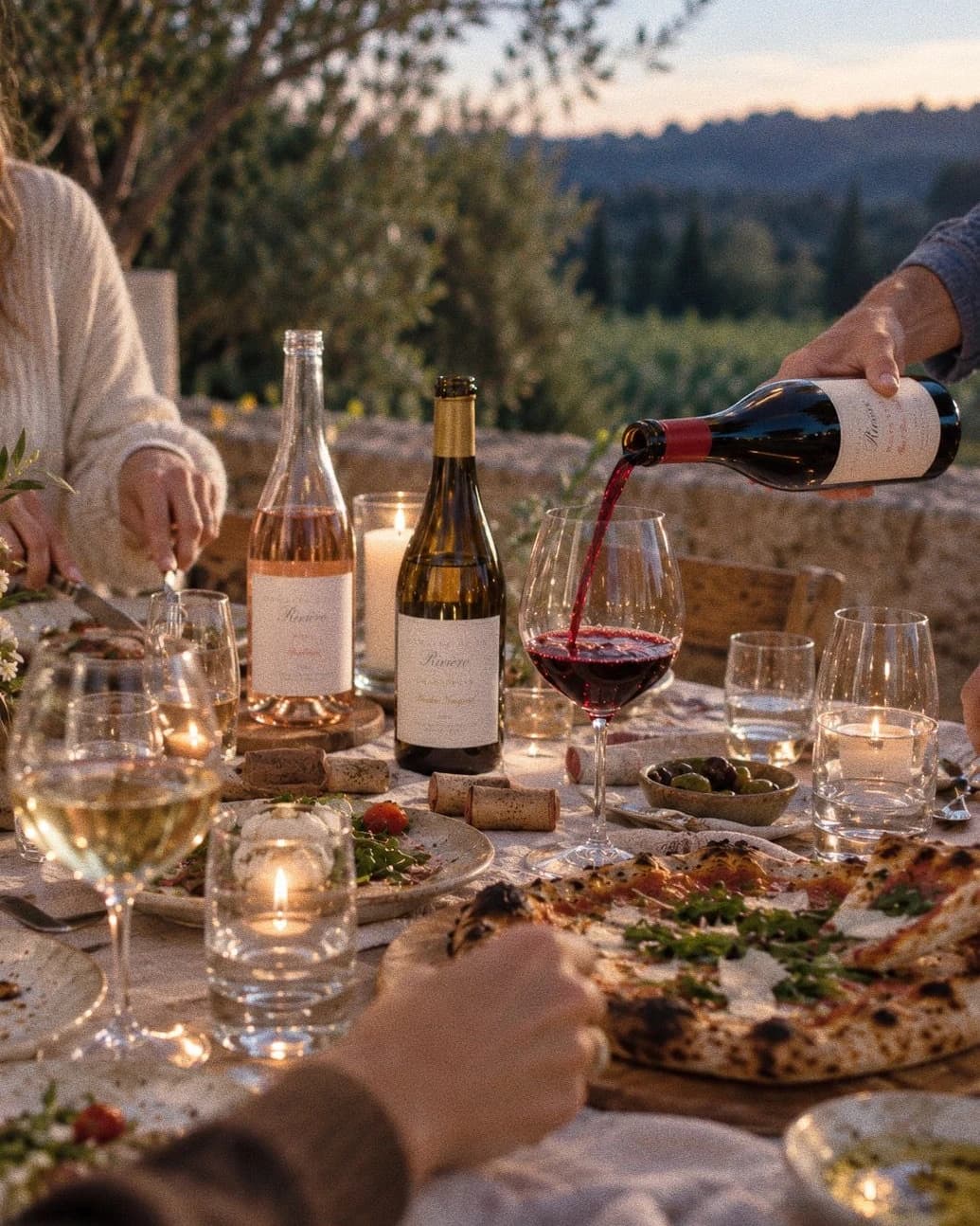 Pouring 2022 Red Barn Block Pinot Noir at a dinner table beside 2025 Shoshana Rosé and 2021 Ritchie Vineyard Chardonnay